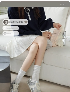Detail of white ballet-style ribbed socks with lace cuffs on model in casual setting