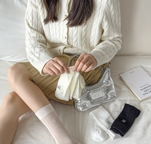Detail of ballet style mesh socks featuring silver bow charms and ribbed knit texture