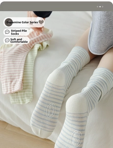 Close-up of colorful striped cotton socks with non-slip brand logo on soles