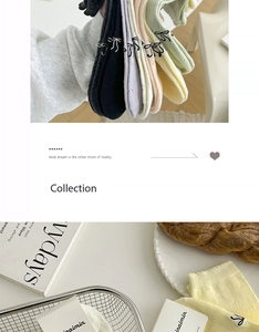 Detail of colorful cotton socks with cute black embroidered bows and lace edges