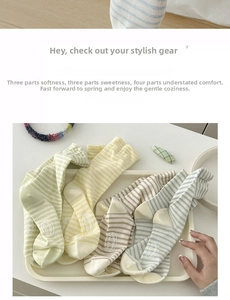 Detail of striped cotton socks in pastel colors with anti-slip logo on soles