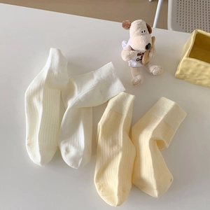 Cozy cream and light yellow ribbed cotton socks displayed with cute decor props