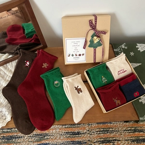 Christmas gift box with cartoon socks featuring festive embroidery in diverse colors