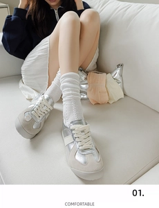 Detail of silver leather sneakers with white geometric textured crew socks for women