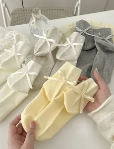 Dettaglio di calzini in cotone con fiocchi di nastro e texture a maglia verticale