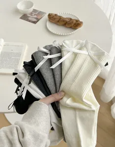 Detailed shot of ribbed cotton socks with bow tie accents in five neutral colors