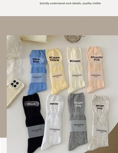 Flat lay of knit mid-calf socks in eight colors showing cable knit texture and variety