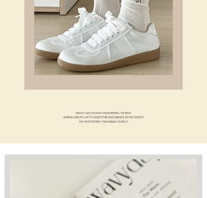 White leather sneakers with gum sole and white ribbed knit socks on wooden floor