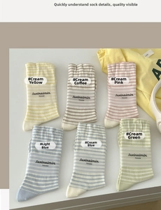 Close-up of pastel striped cotton socks with letter embroidery in various macaron colors