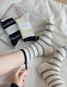 Detail of striped crew socks with ribbed texture and decorative fabric heel labels