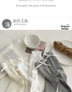 Detail of cream and grey ribbed crew socks featuring delicate satin bow accents