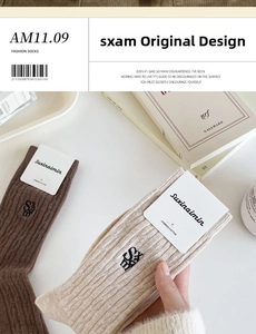 Detail of combed cotton mid-calf socks with black S letter embroidery in a soft setting