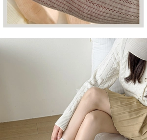 White cable knit cardigan and pleated mini skirt set styled with a baseball cap