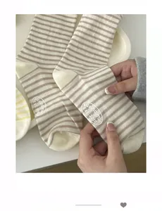 Detail of striped cotton socks showing anti-slip white letter printing on the sole