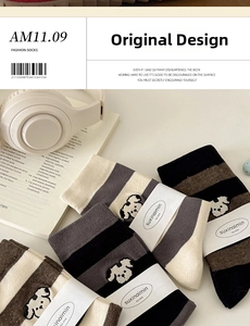 Detailed view of striped crew socks with cute dog embroidery and branding labels