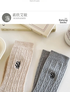 Detail of knit crew socks set with embroidered logo in beige and light grey tones
