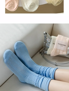 Detailed macro view of ballet style cable knit crew socks in soft cotton pastel colors