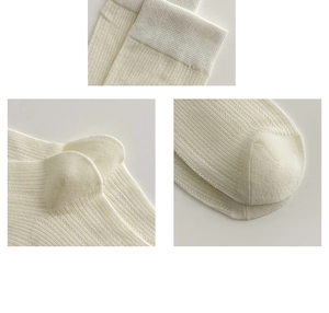 Macro detail of cream ribbed knit fabric showing elastic cuff and seamless toe stitching