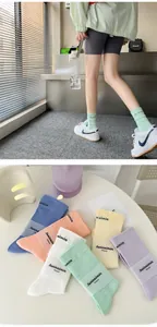 Detail of cream-colored ribbed crew socks in assorted pastel shades with knitted logo