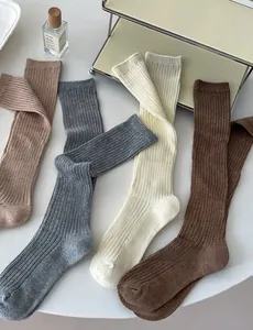 Detail of four-color ribbed knit crew socks in beige grey brown and pink cotton