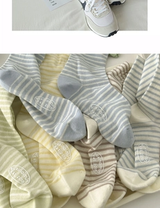 Detailed view of striped cotton socks with embroidered logo and casual sneakers