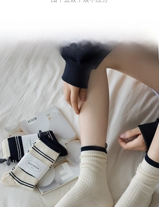 Detail of ribbed knit crew socks with navy stripes and elastic double-layer cuffs