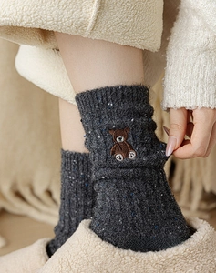 Gros plan de chaussettes en tricot de laine avec broderie d'ours en décor chaleureux