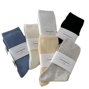 Five-pack of solid color cotton ribbed crew socks in assorted neutral and pastel colors