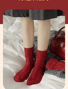 Detail shot of vintage red knitted wool socks with classic cable-knit texture and folds