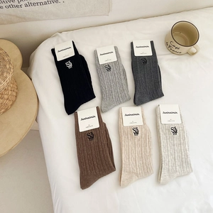 Six pairs of ribbed mid-calf socks with letter embroidery in warm neutral tones