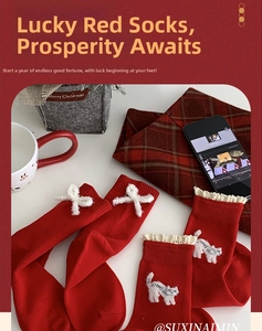 Cozy red New Year socks with white bows and kitten embroidery on checkered tablecloth