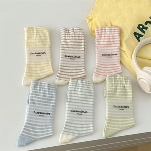 Set of six colorful striped mid-calf socks in pastel tones with trendy branding labels