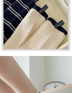Detail of ribbed knit crew socks with contrast stripes and decorative side labels