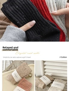 Detail of colorful speckled knit wool socks with branding label in cozy setting