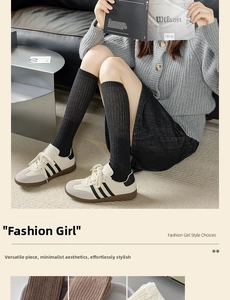 Detailed texture of ribbed knit black calf socks paired with white leather sneakers