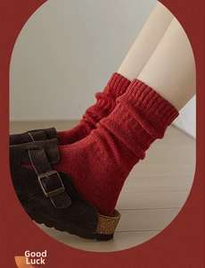Close-up of red ribbed knit mid-tube wool socks with stylish suede slippers for Christmas