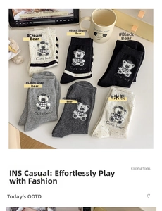 Detailed flat lay of cute bear patterned socks in neutral cream, grey, and black tones