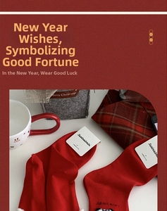 Detail of red New Year socks with white faux shearling trim and cute puppy embroidery