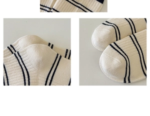 Close-up of ribbed knit texture on cream socks with navy stripes and detailed stitching