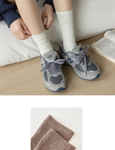 Close-up of ribbed knit texture and elastic cuffs on brown and white crew socks