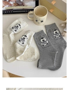 Detail shot of cute bear embroidery and ribbed cuffs on beige and grey cotton socks