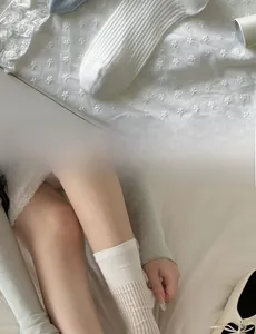 Dettaglio di calzini in cotone bianco e azzurro con trama a costine morbide indossati da modella