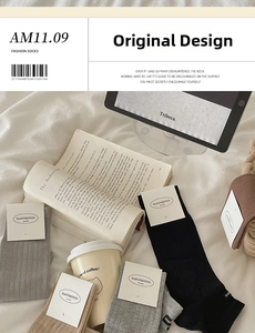 Flat lay of multiple cotton knit socks in neutral tones with minimalist ribbed texture