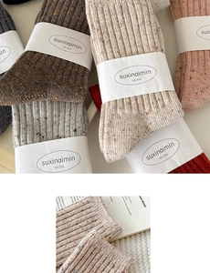 Detailed texture of thick ribbed wool socks with colorful speckled knit patterns