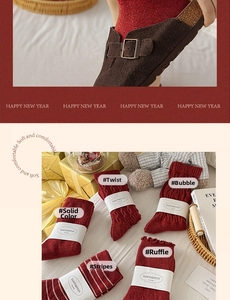Detail of five assorted red knit wool socks with various textures in a gift box