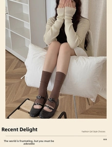 Detail of brown ribbed knit socks paired with black double-strap Mary Jane shoes style