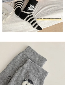 Detail of cute bear embroidery on striped cotton socks with cozy knitted texture