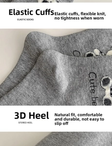 Detail of grey knitted mid-tube sock featuring cute bear print and elastic ribbed cuff