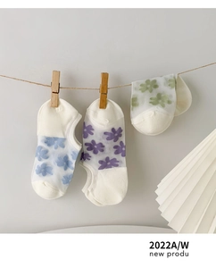 Dettaglio di calzini in rete floreale blu, viola e verde con suola in cotone traspirante