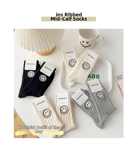 Detail of cotton crew socks featuring ribbed texture and smiling face embroidery